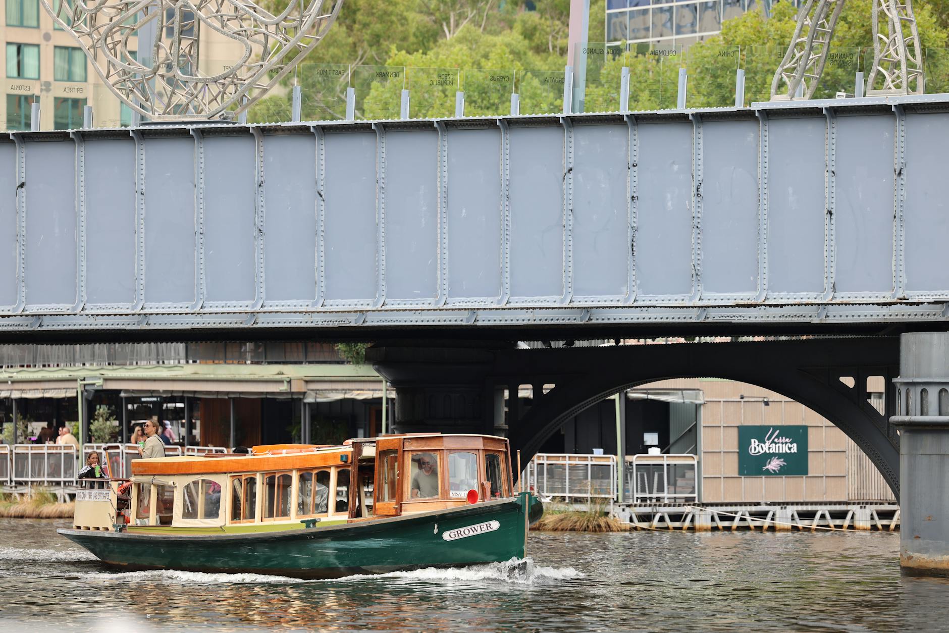 Tradycyjna łódź na Wiśle przepływa pod mostem w centrum miasta