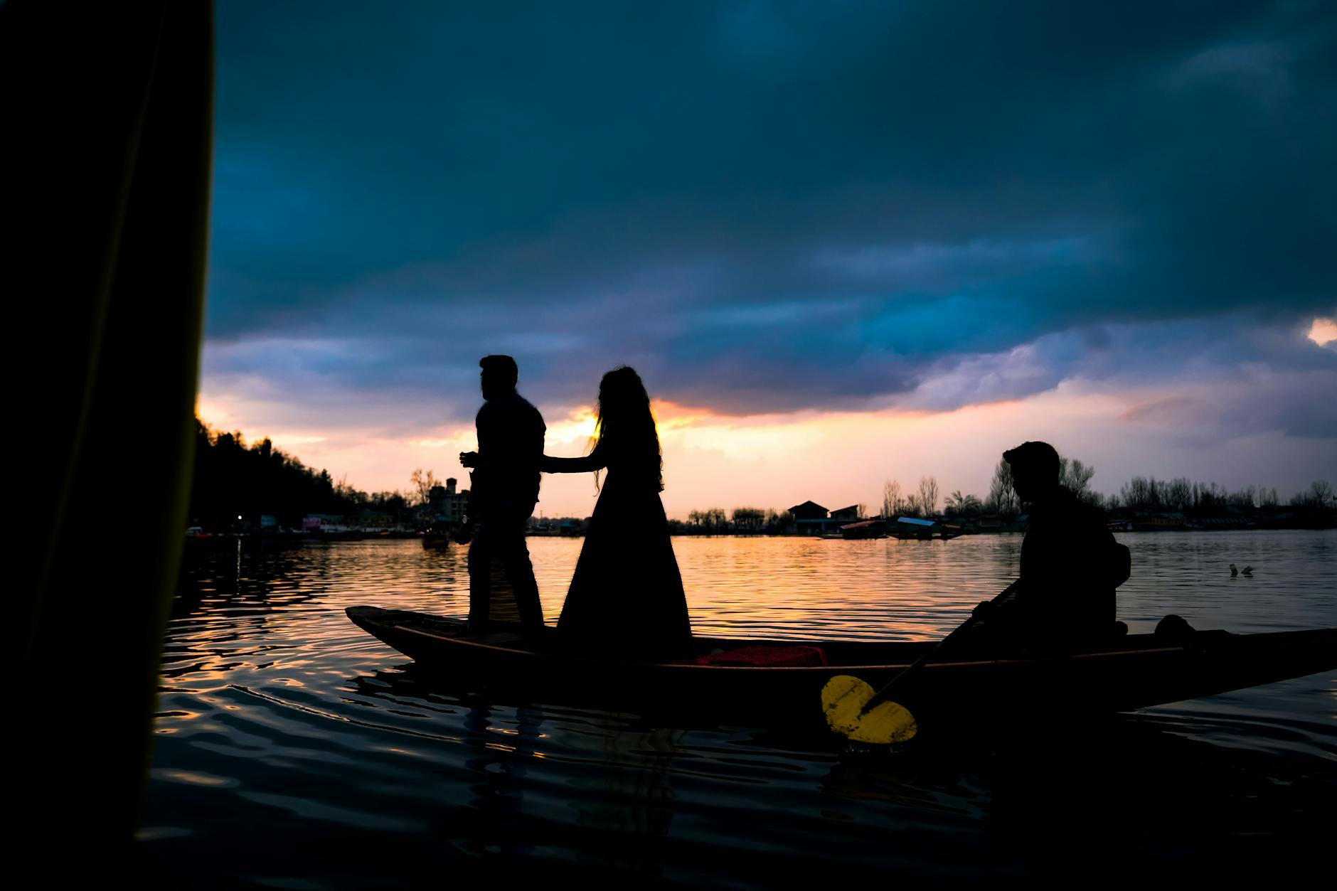 Para w łodzi na jeziorze w Austrii o zachodzie słońca