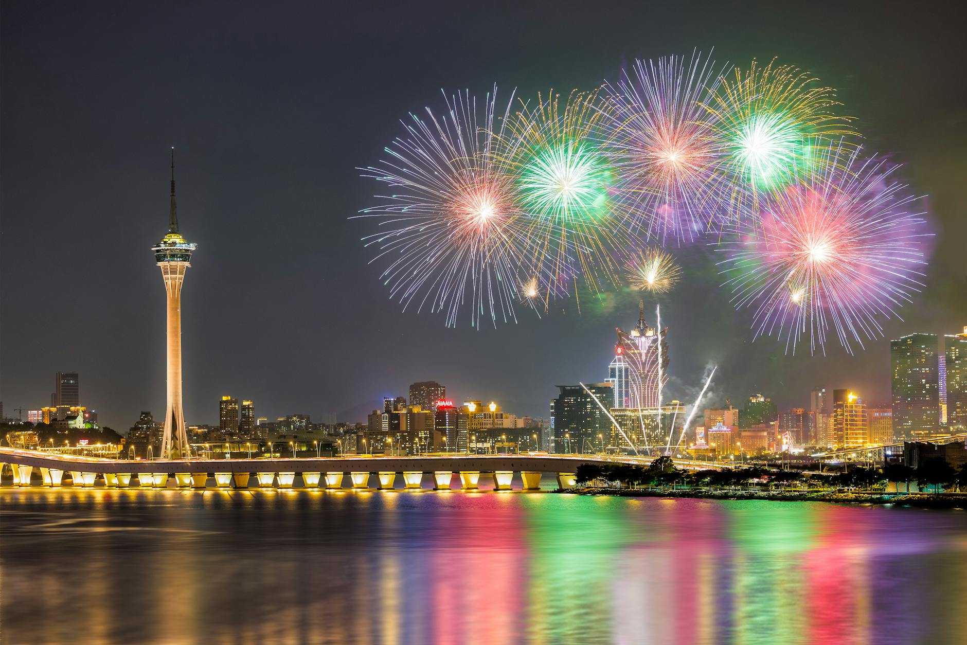 Nocna panorama Makau z fajerwerkami odbijającymi się w wodzie Nocna panorama Makau z fajerwerkami odbijającymi się w wodzie